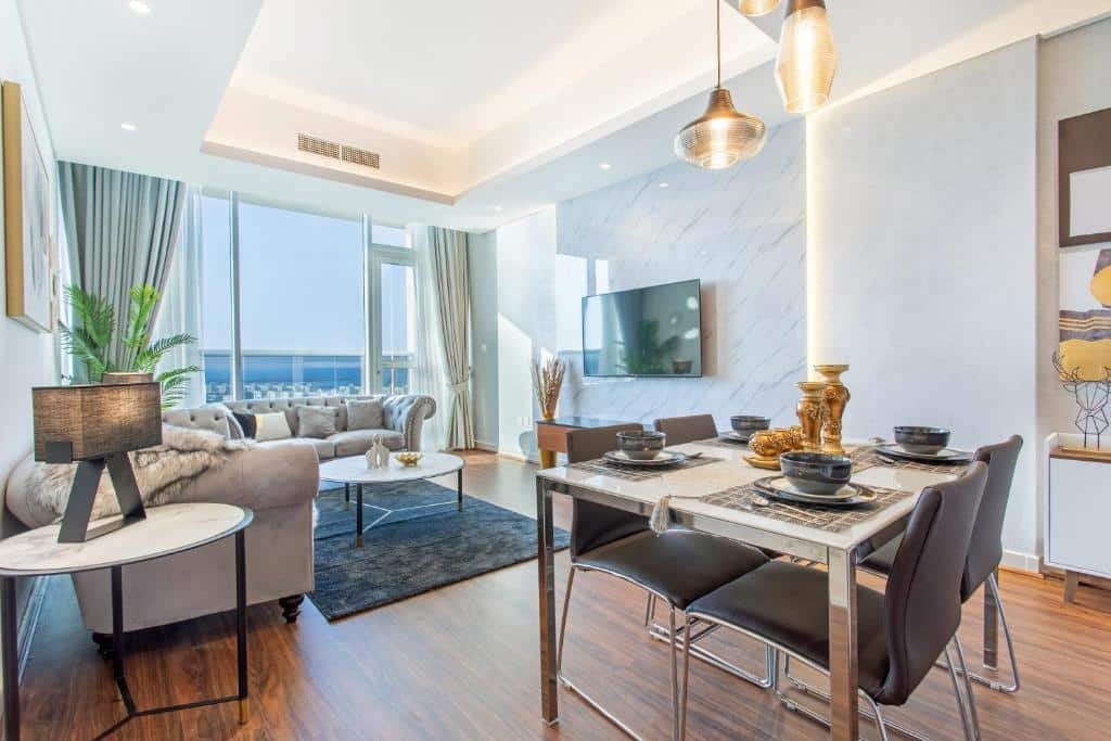 Sala de estar e de jantar no Live in the middle of Lagoons and Sea, há dois ambientes, em um está a sala, com sofás, televisão, mesinha de centro e uma varanda com vista para o mar, do outro lado, há uma mesa com quatro lugares